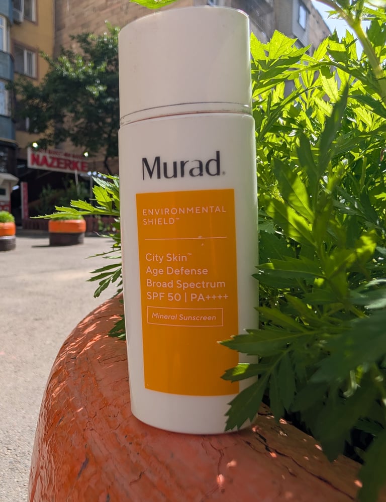 Murad Environmental Shield City Skin Age Defense Broad Spectrum SPF 50 mineral sunscreen bottle outdoors.