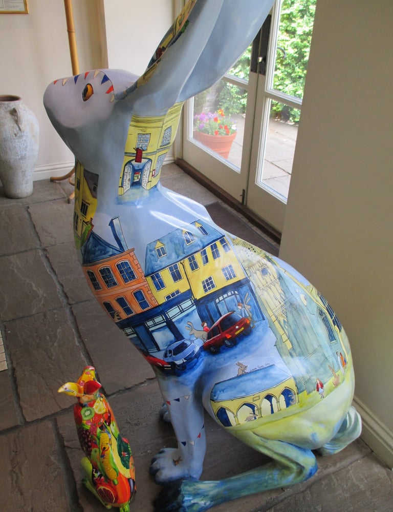 Hare sculpture featuring Cirencester scenes, painted by Laura Fearn