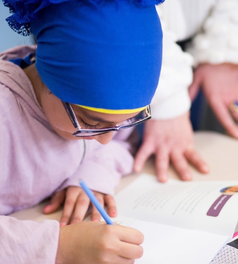 Elementray girl uses a workbook to share her thoughts.