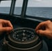 A person holding a compass on a boat