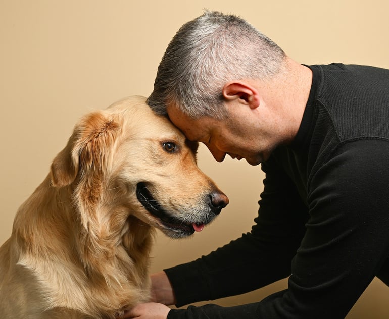 a man is petting a golden retriever