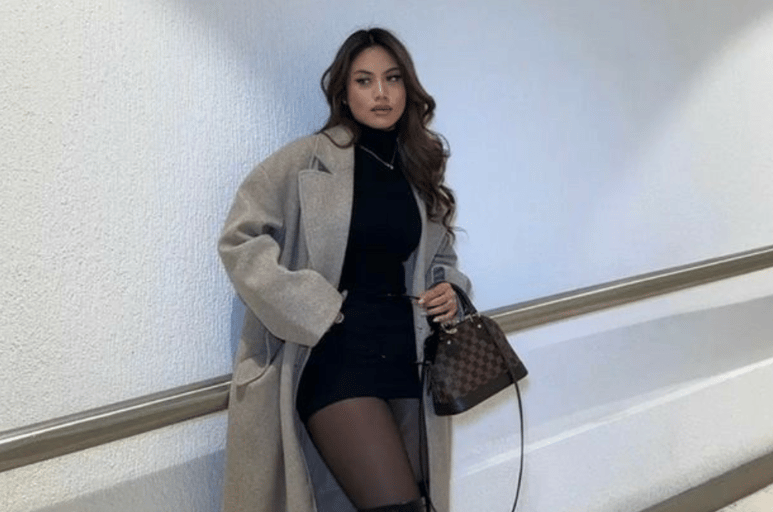 a woman in a black dress and boots is posing for a picture