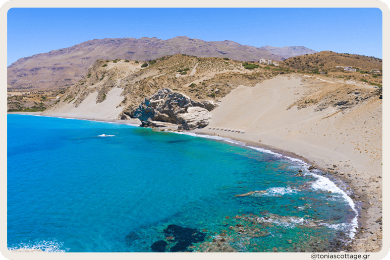 Agios Pavlos Sandhills in Crete, Greece with a scenic sea view, featuring sunbathers in the distance