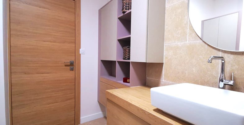 Meuble en chêne clair, portes anti trace de doigts, vasque posée sur plan, travertin sol et mur.