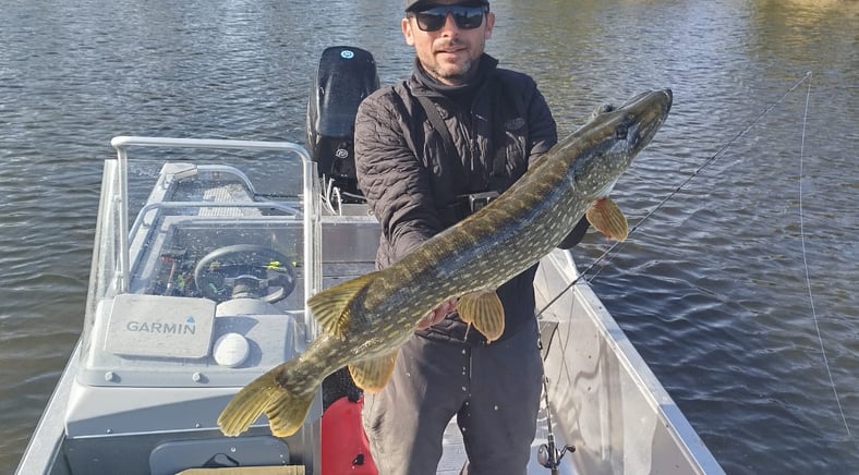 en fiskare är på en fiskebåt, båten är en "linder 460". han fångade en gädda i Sverige.