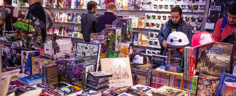 a bunch of people standing around a table with a lot of toys