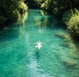 Person by tranquil water, representing peaceful and lasting transformation