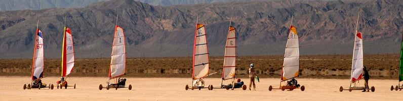 a group of people are sailing on the beach