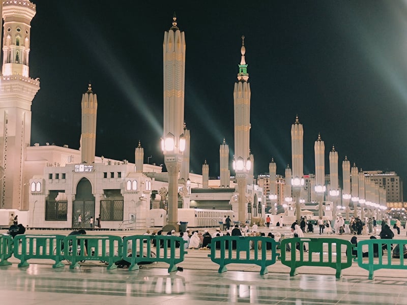 Masjid Nabawi illuminated at night with towering minarets