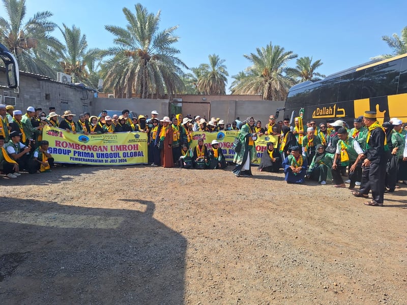 Pilgrim group photo in front of Dallah executive buses