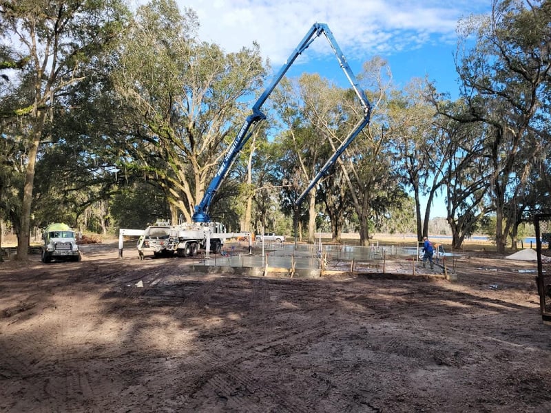 Croft boom pump reaching across a rural jobsite in North Florida