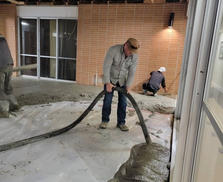 Croft operator placing concrete on a commercial flooring job