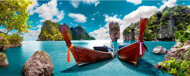 two boats in the water with a blue sky and clouds