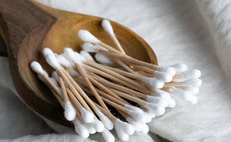 Bamboo cotton swabs in a wooden dish.