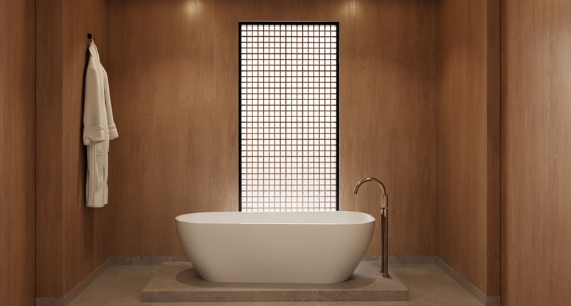 Freestanding bathtub in wood-paneled minimalist bathroom with soft lighting and grid-screen window.
