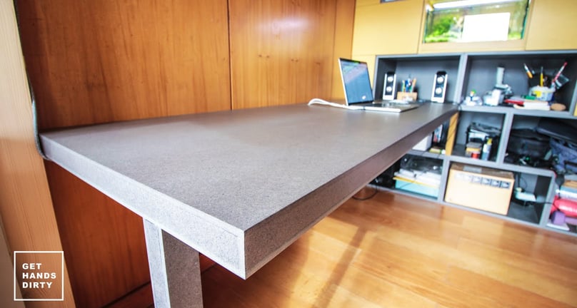 An almost floating working desk underneath a loft bed built with colored MDF.