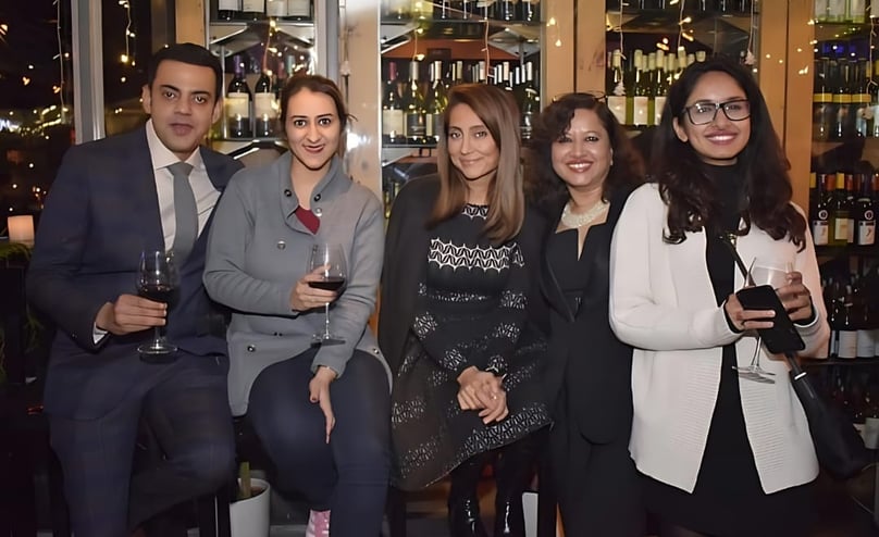 a group of people standing around a bar