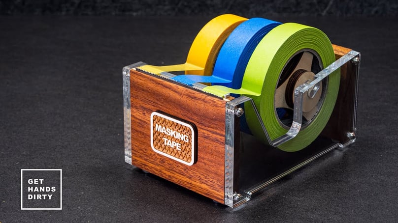 A multi roll tape dispenser made out of wood, acrylic and a bandsaw blade.