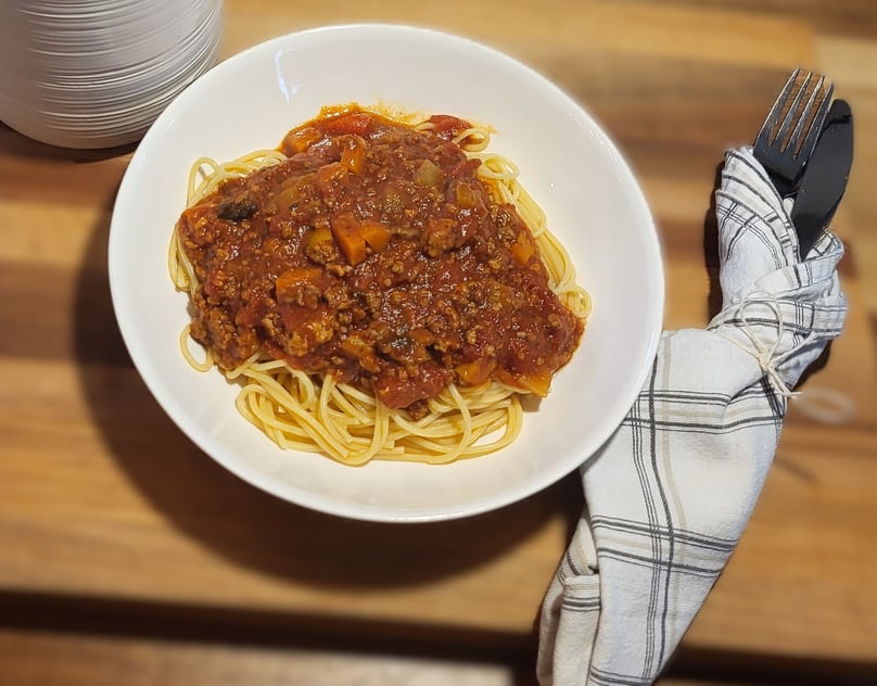 a bowl of spaghetti sauce with spaghetti and meat