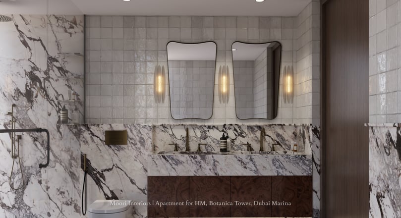Marble-clad bathroom with two distinct mirrors and gold fixtures.
