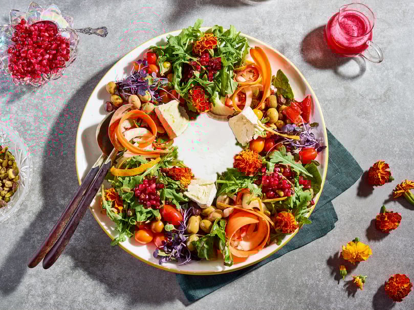 a plate of food with a wreath of vegetables and fruit