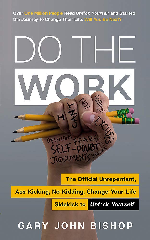 a person holding pencils and writing on a book