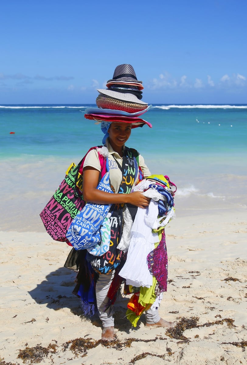 Beach vendor selling hats and souvenirs in Punta Cana, Dominican Republic with ocean background