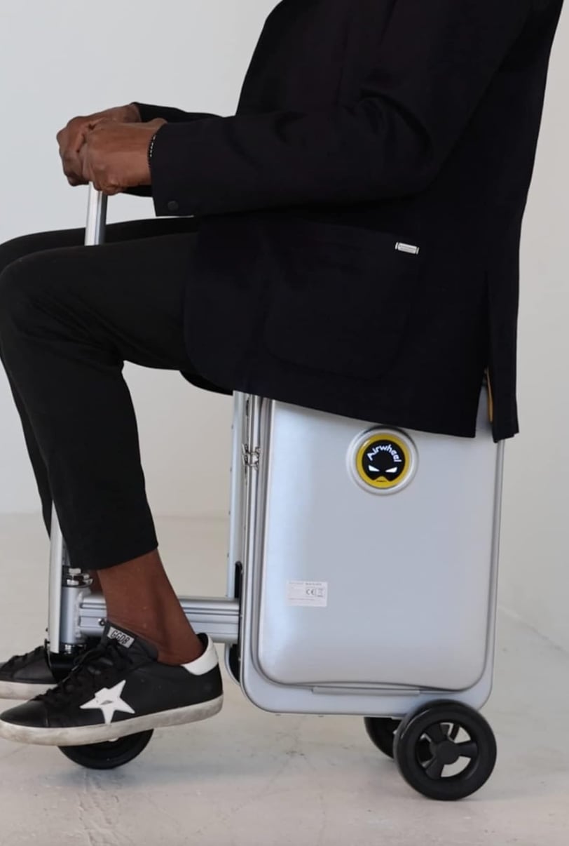 a man sitting on a suitcase with a suitcase