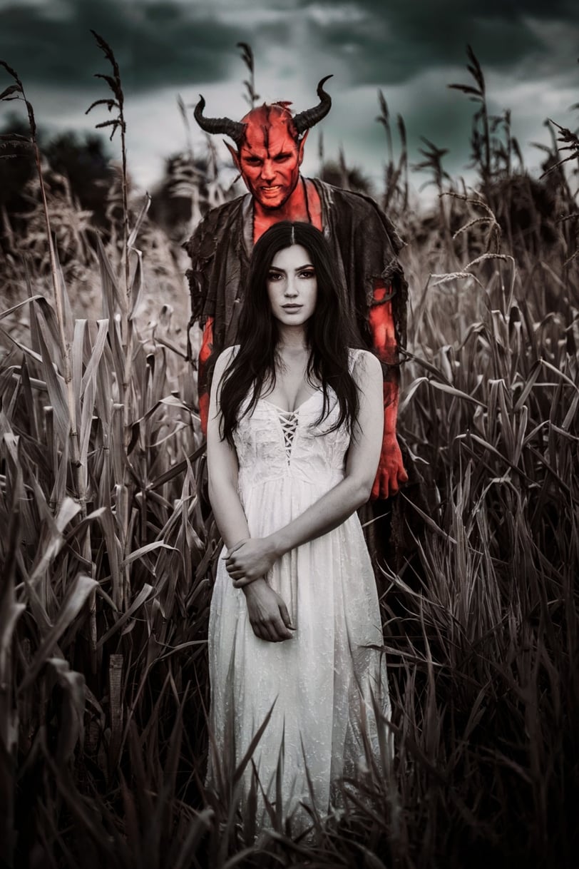 a woman in a white dress and devil horns costume
