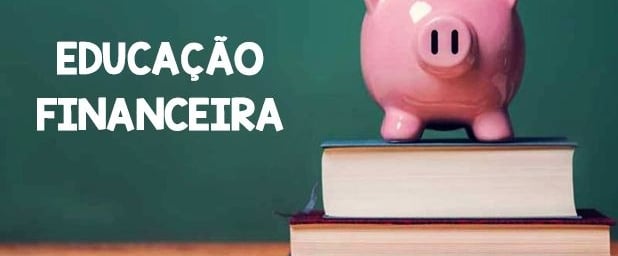 Um cofrinho no formato de um porquinho cor de rosa sobre livros e ao fundo um quadro negro de escola