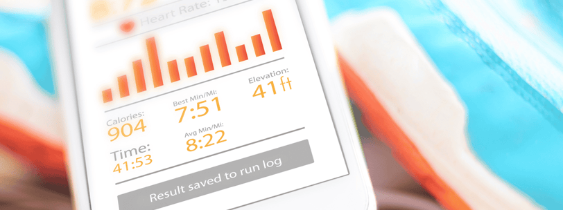 a cell phone in front of a pair of running shoes