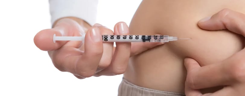 woman injecting weight loss medication in belly