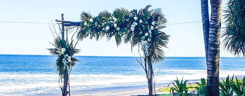 a beach wedding ceremony with a view of the ocean