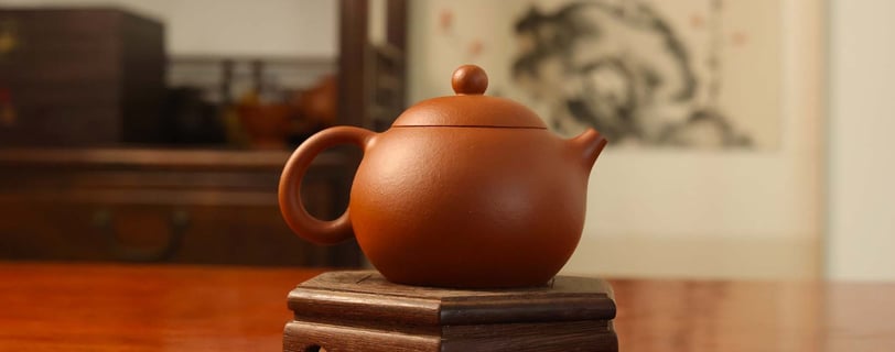 Round-shaped teapot placed on a wooden stand
