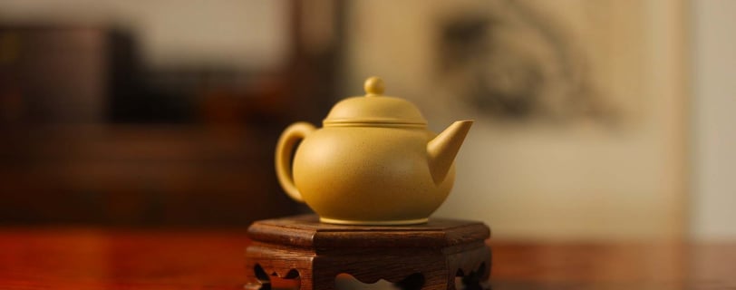 Light yellow teapot placed on a wooden stand
