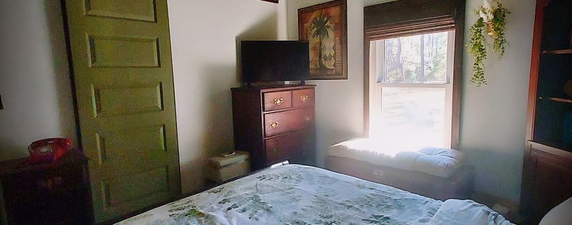 a bedroom with a bed and a television