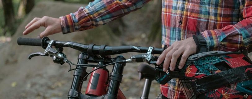a man in a plaidered shirt and a bicycle