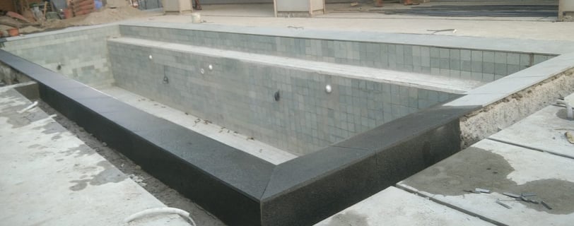 kolam renang struktur beton dengan finishing batu hijau