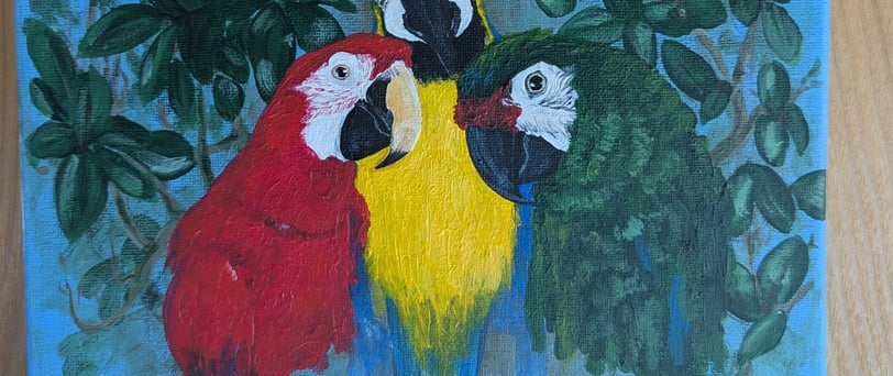 Progress photo of small canvas acrylic painting of three macaws.