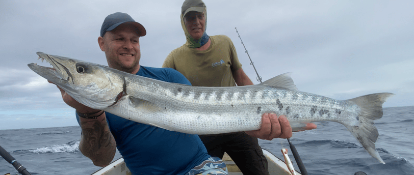 An angler holding a freshly caught Barracuda during the peak Zanzibar fishing season