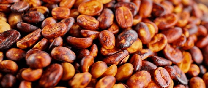 a pile of roasted beans on a wooden table