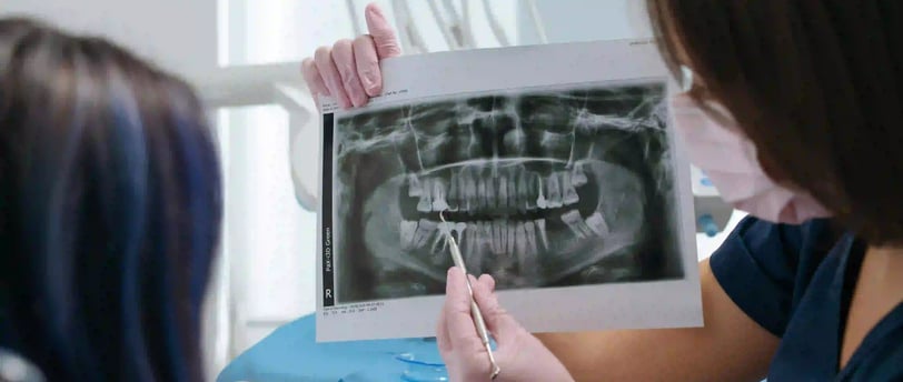 a woman in a dentist's office with a dentist's hand holding a