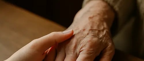 Main d'une jeune femme tenant la main d'une dame âgée