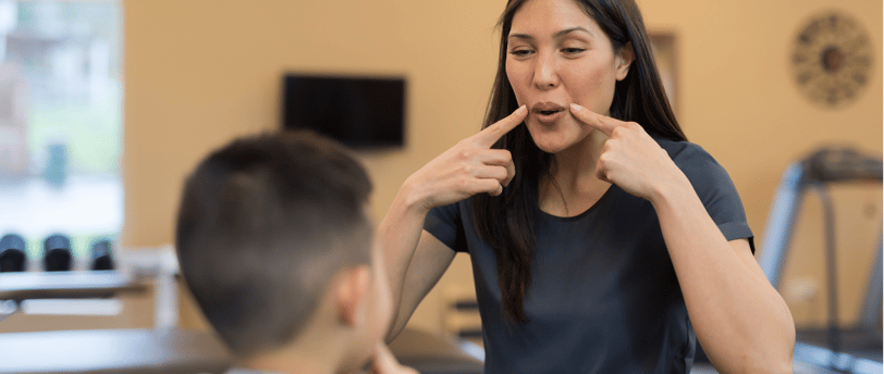 Fonoaudiologa ensinando autista. a woman in a gym room with a man brushing his teeth