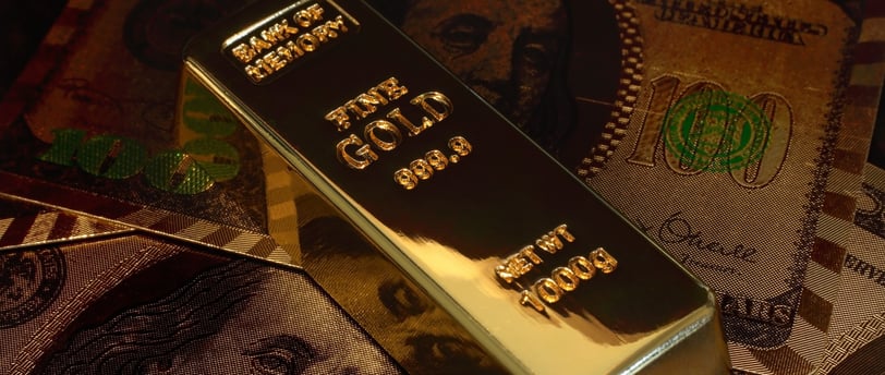 gold bar on top of US money