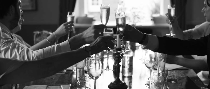 Classy black and white photo of wedding guests drinking champagne