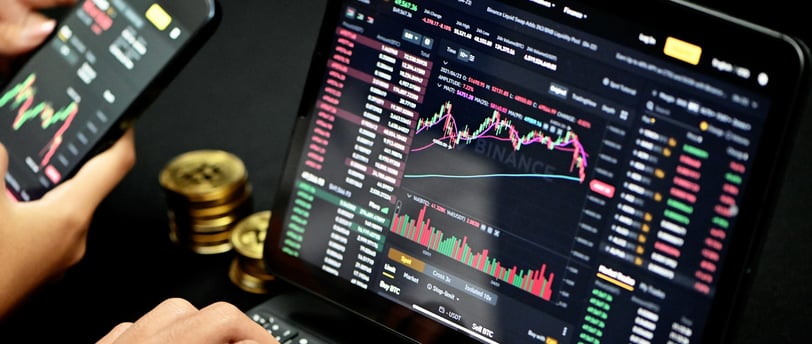 person trading on their computer with bitcoin on the side