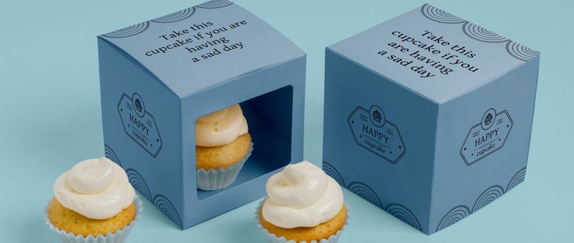 a cupcake in a box with a card