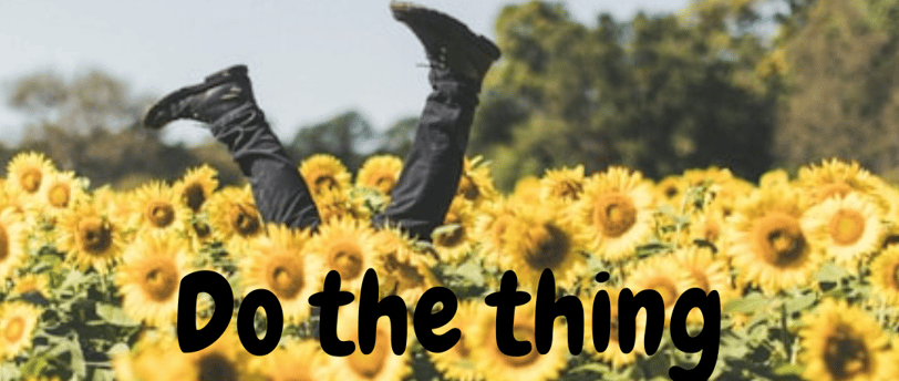 a person doing a handstand in a field of sunflowers