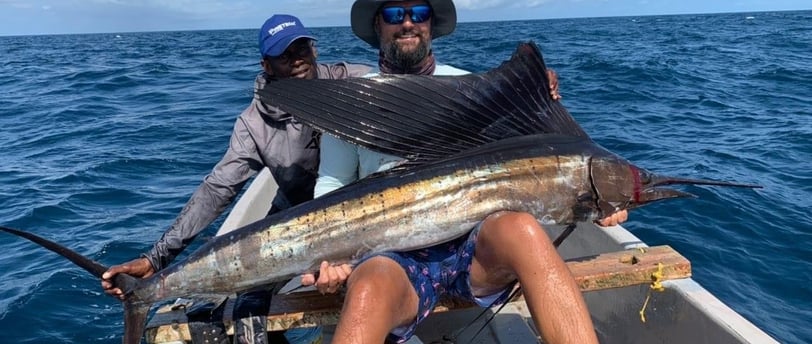 big game fishing Zanzibar - a man holding a sailfish in a boat